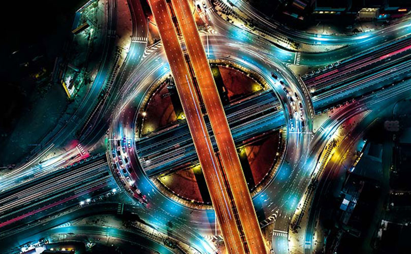 A shot from above of a highway with lights going through the road