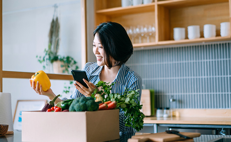 Woman shopping for home groceries on mobile app device