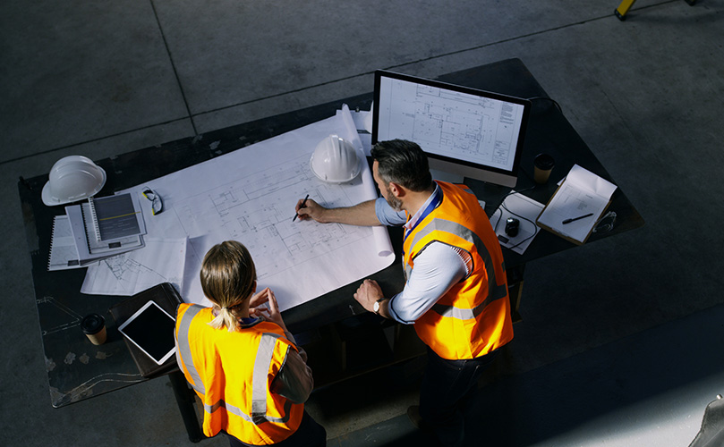 Images of two engineers discussing drawings