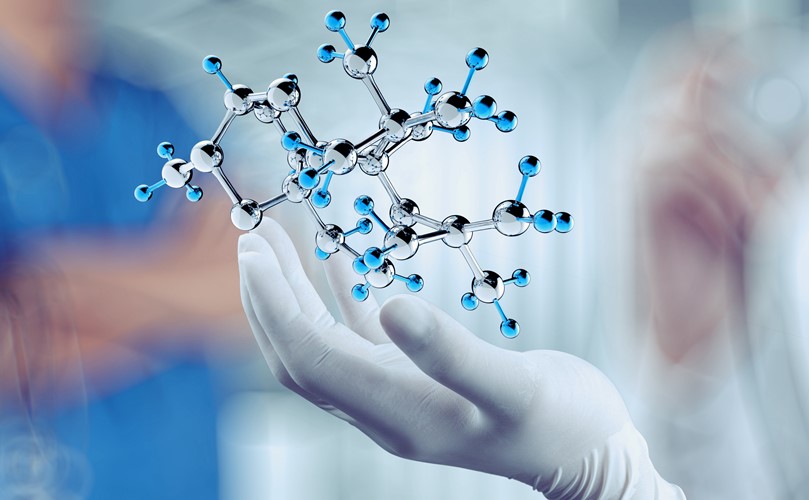 A hand holding a chemical reaction model