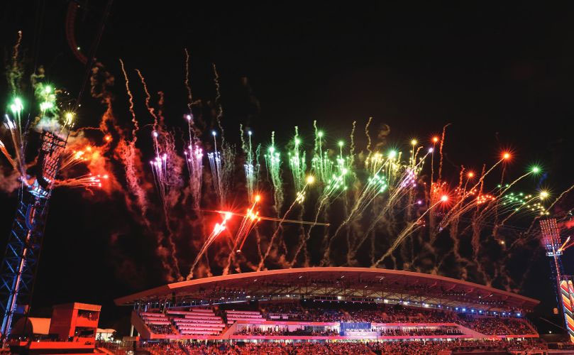 Fireworks display over a crowded stadium at night