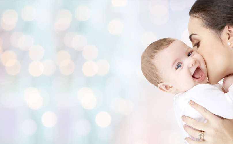 A woman holding a baby that’s smiling