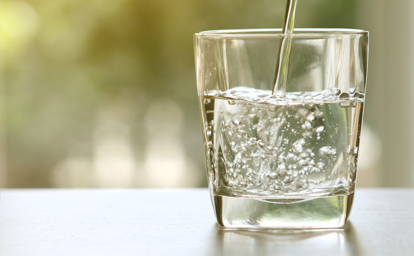 a glass of water being poured into a glass