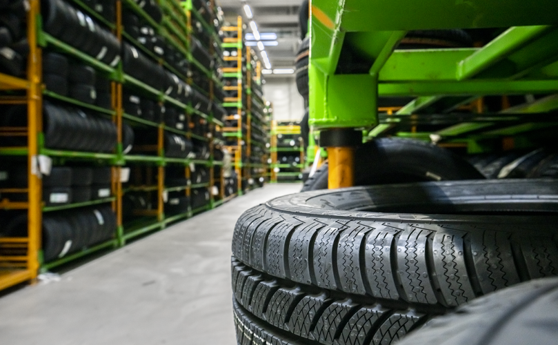 Main focus on a single tire while the background showcases the inside of a tire storage