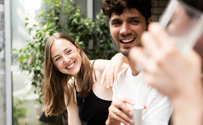 A group of friends joyfully laughing and smiling, capturing a lively and positive atmosphere among them.