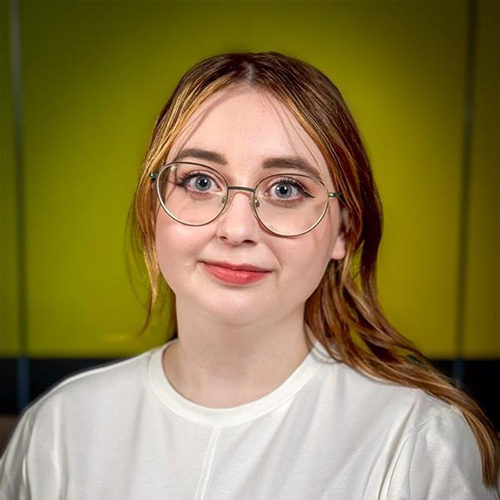 Headshot of Brónach McCartney wearing glasses with strawberry blonde hair.