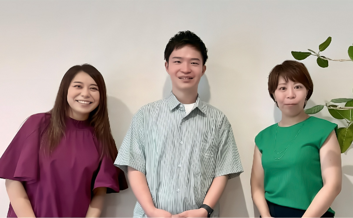 3人が壁を背にして並んでいる写真