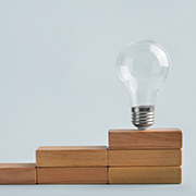 階段状に並べられた木製ブロックの一番上に電球の画像