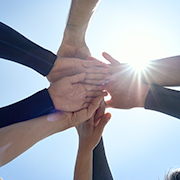 空に向かって重ねられた手、協力と団結の象徴