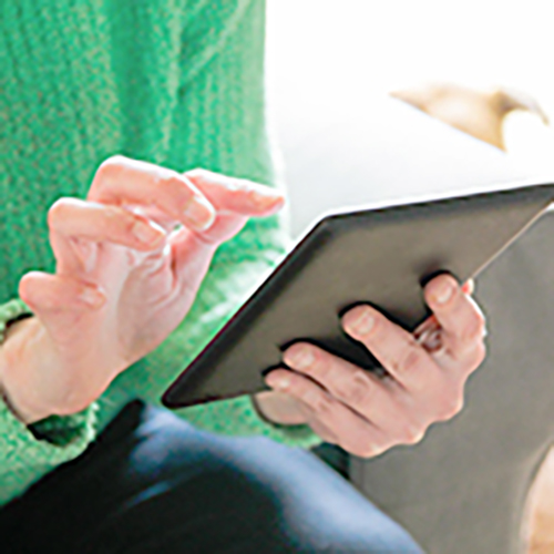 タブレットを操作する女性の手元クローズアップの画像