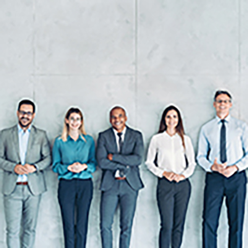 壁際に並んで立つ様々なビジネスパーソンの画像