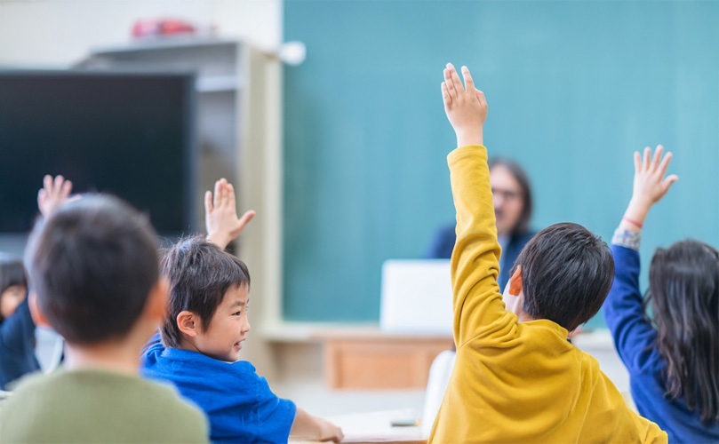教室で質問に対し手を挙げる生徒たち