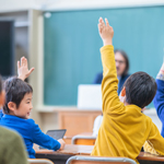 教室で質問に対し手を挙げる生徒たち
