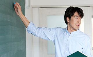 黒板に向かっている教師