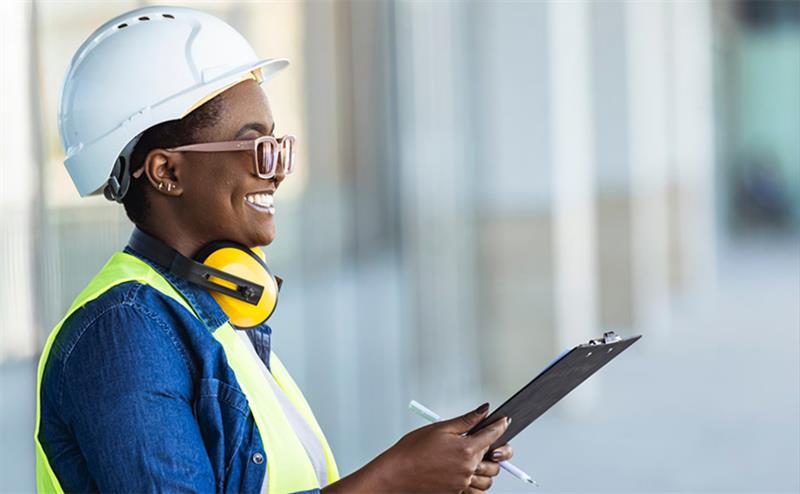 a person wearing a hard hat and earphones holding a clipboard