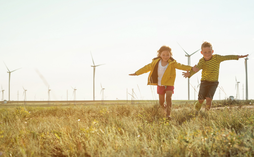 Two children running through a field