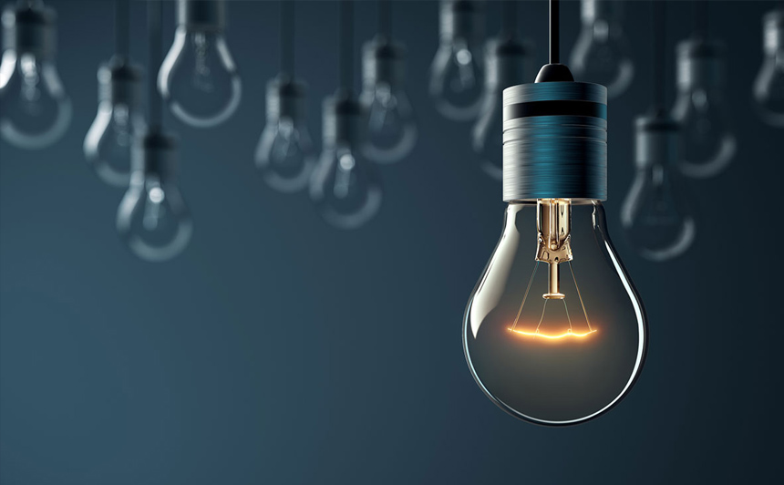 Fokus på en glödlampa med flera andra ur fokus på en mörkblå bakgrund