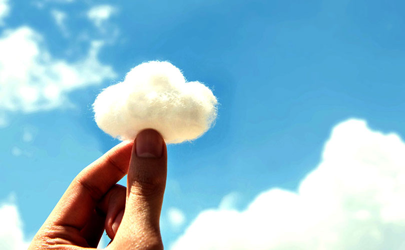 Käsi vanulappua, joka näyttää pilveltä ja taustana taivas