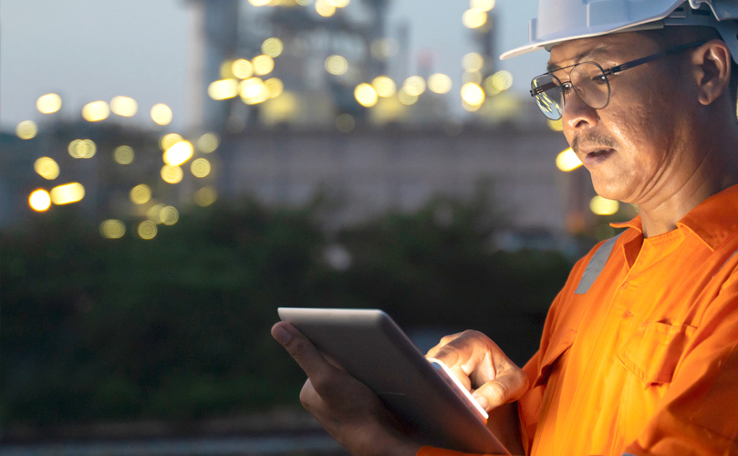 A man in protective gear looking at a tablet