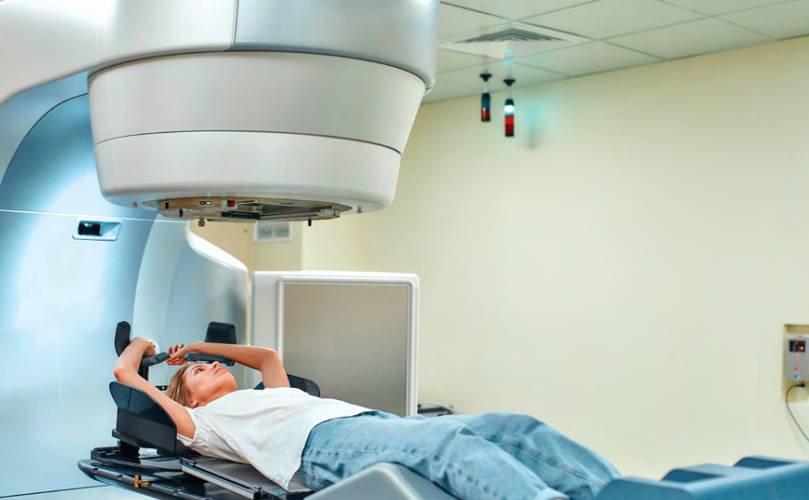 Một người phụ nữ nằm xuống, nhìn vào một cỗ máy trên đầu của cô