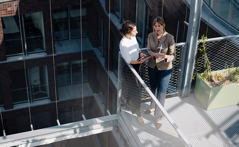 a person talking to another person on a balcony