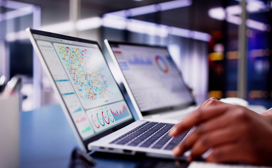 Close-up of a laptop, actively used by hands for office tasks.