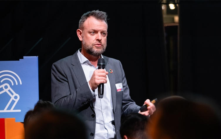  A man in a suit delivers a speech at a conference