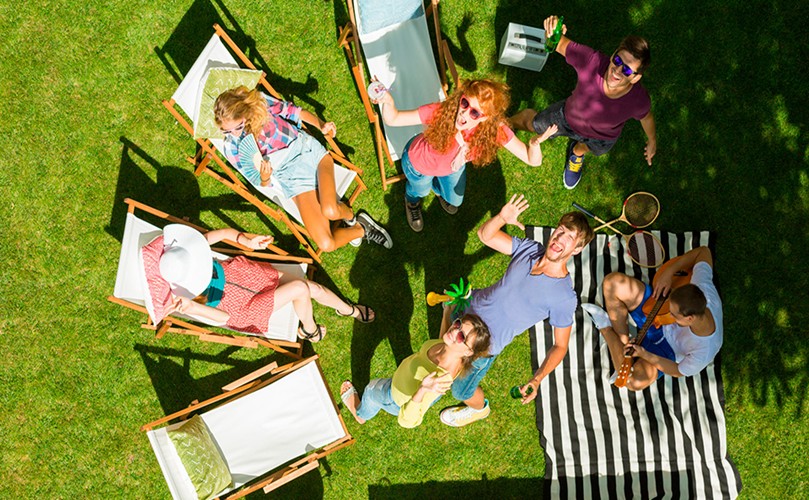 A group of people sitting in chairs on grass