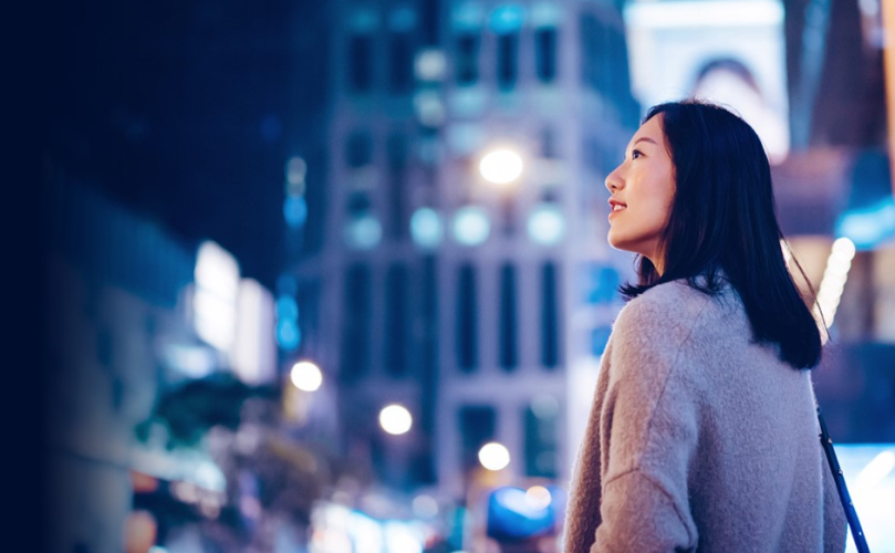 一個女人站在街上，沉思地看著外面的東西。