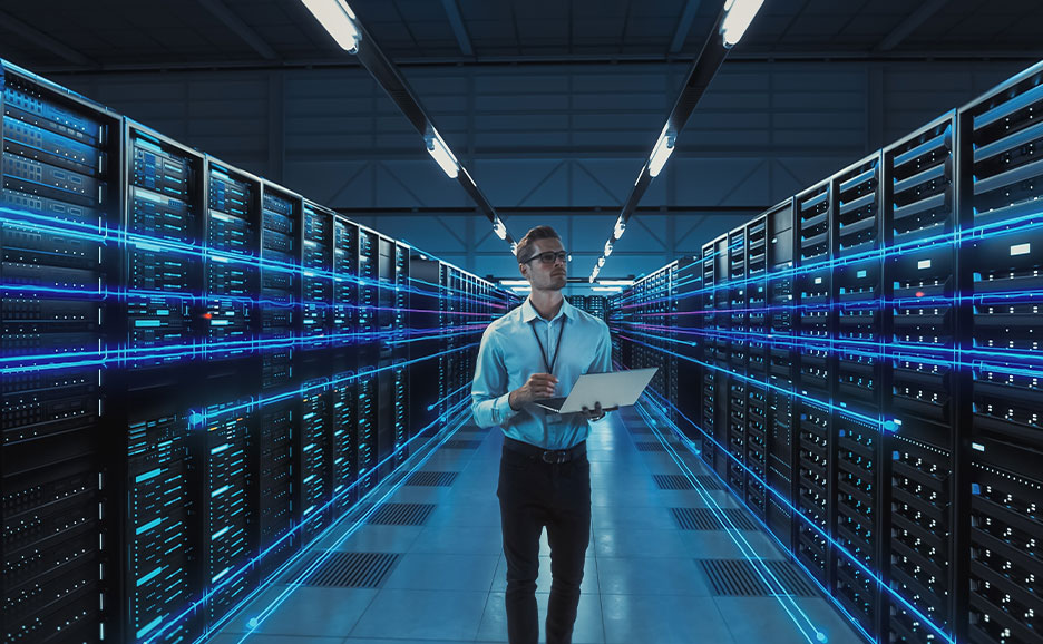 Ein Mann steht in einem Rechenzentrum mit einem Laptop. Mehrere neonfarbene Lichtlinien überlagern die Datenserver