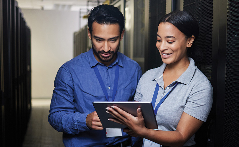  IT-Fachkräfte arbeiten mit Tablet zwischen Servern