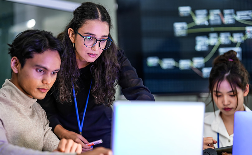 Image of colleagues reviewing their laptops
