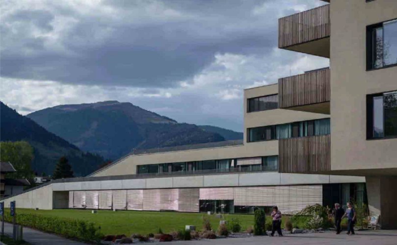 The outside of a building with a mountain top on the background