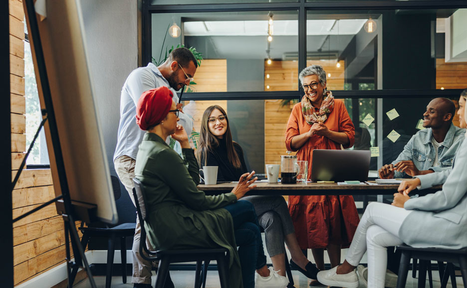 Happy businesspeople smiling cheerfully during a meeting in a creative office