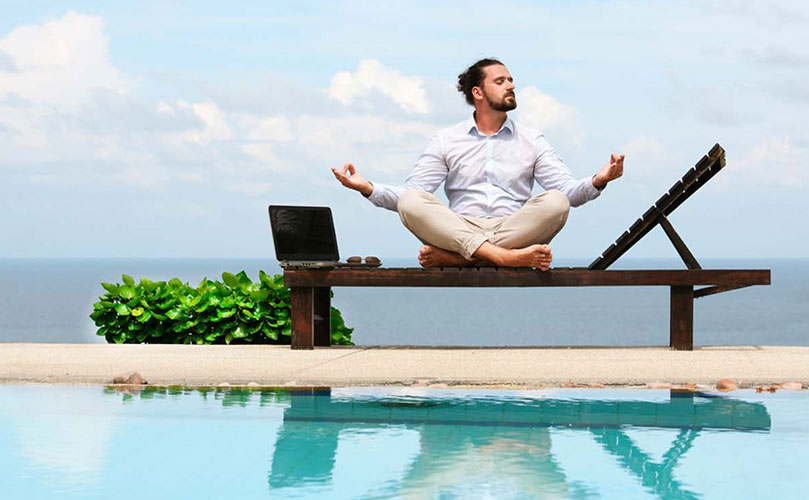 Mies uima-altaan lähellä, meditoi rantatuolissa tietokone vieressään