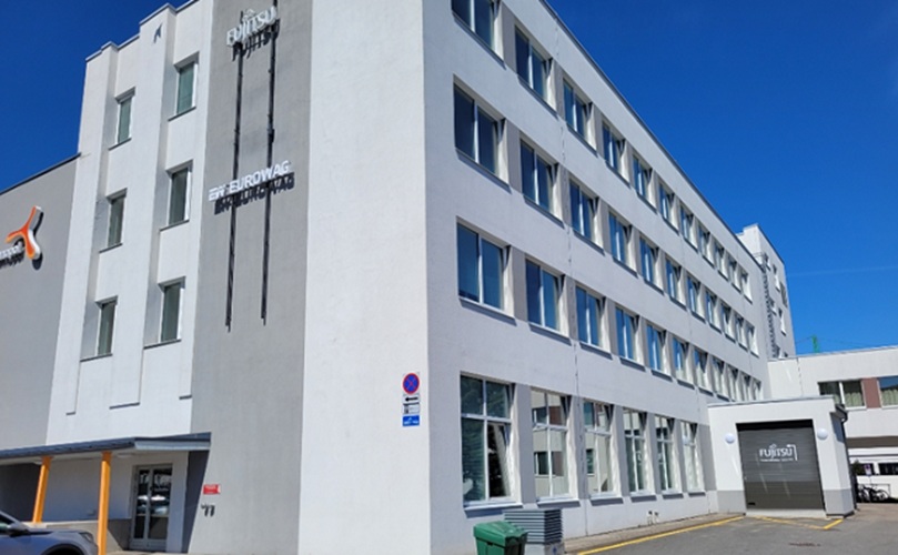 A large white building with a noticeable sign affixed to its facade.