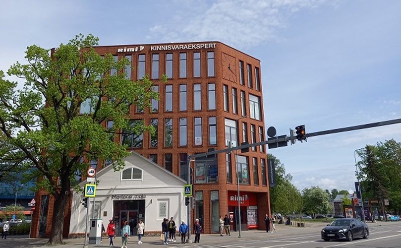 A red brick structure with a prominent large window on the side, highlighting its classic architectural style.