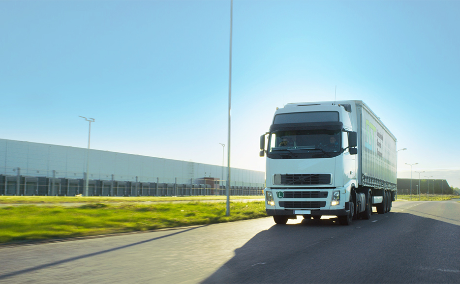 晴れた日に道路を走行するトラックの写真