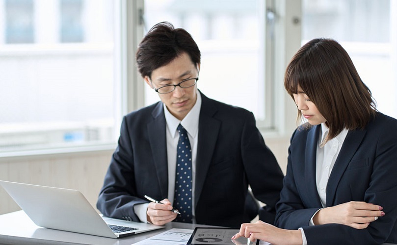 女性従業員に業務をレクチャーする男性社員