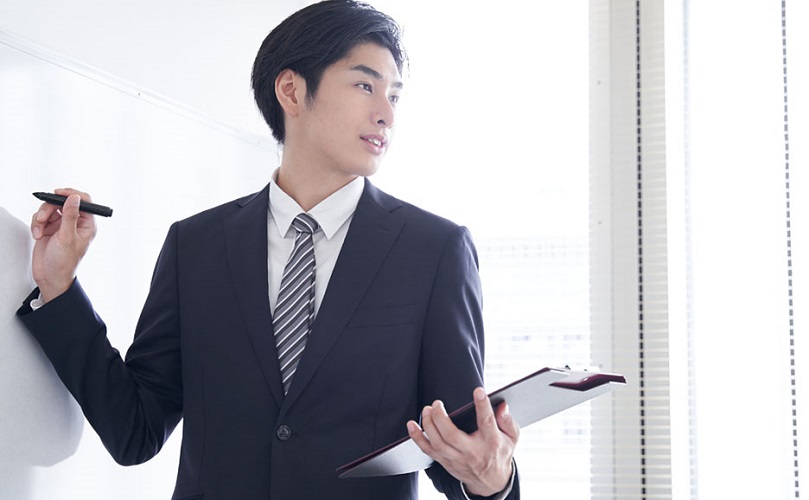 ホワイトボードの前で説明する男性