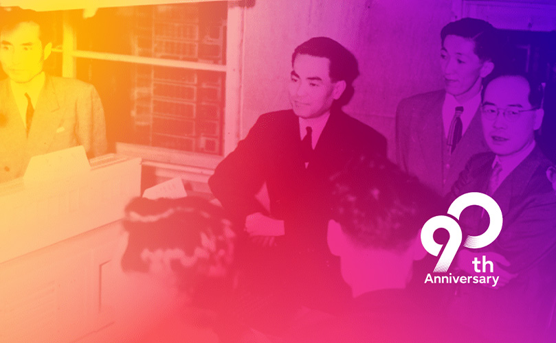 Der FACOM100, Japans erster relaisbasierter Computer von Fujitsu, umgeben von Toshio Ikeda (dritter von rechts) und dem Physik-Nobelpreisträger Dr. Hideki Yukawa (zweiter von rechts).