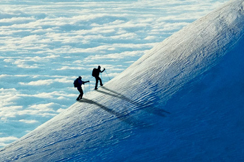 um grupo de pessoas a escalar uma montanha com neve