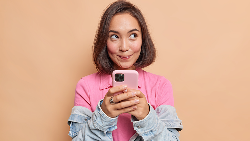 young woman looking at her smartphone depicting health operability solutions
