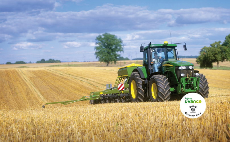 Un hombre montado en un tractor en medio de un campo de maíz