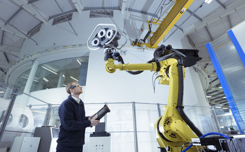 Persona que opera un robot en una planta de fabricación digital