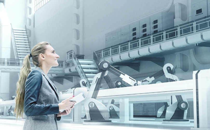 Uma mulher com um tablet na mão, em pé numa fábrica moderna, a observar as máquinas ao seu redor