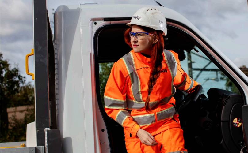 A woman in protective gear exiting a truck