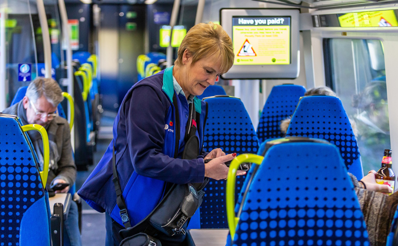 A woman checking the tickets on the train