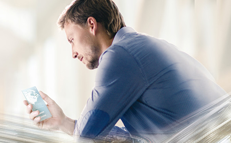 A man sitting looking at his phone