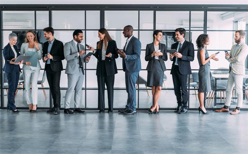 A group of ten people chatting in an office